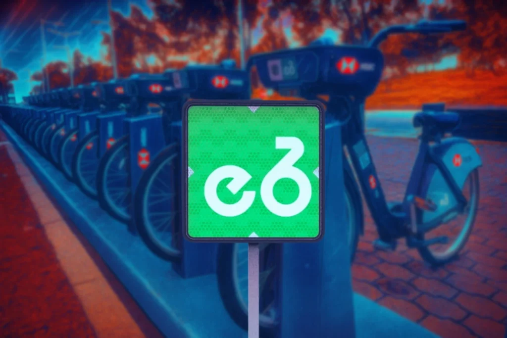Señal de Ecobici de movilidad integrada en color verde, colocada junto a un punto de bicicletas compartidas en la CDMX. Marca el acceso al sistema de transporte urbano en bici.  Parte de las Señales de movilidad integrada.