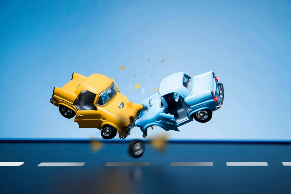 Accidentes en auto representados con dos coches chocando de frente, ejemplo visual de colisión y cultura vial preventiva.